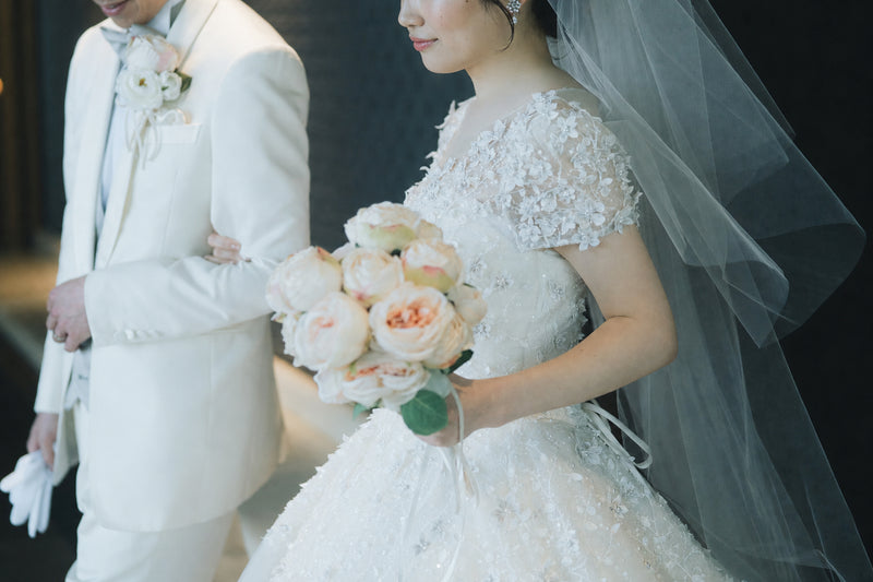 挙式当日、ブーケを手に歩く新郎新婦